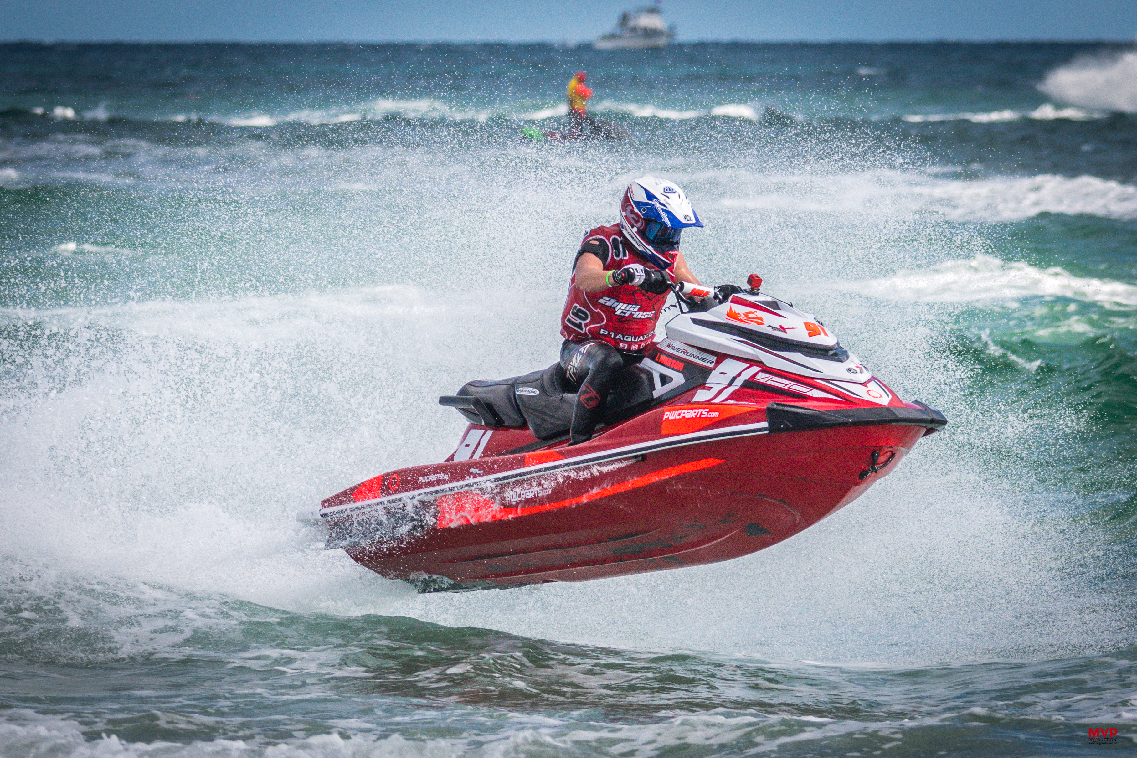 man riding red personal watercraft on water